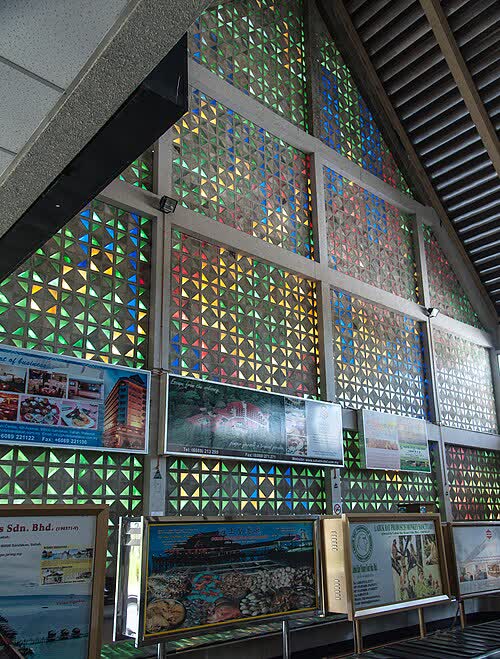 山打根舊機場建築的彩色玻璃牆壁裝飾,照片攝於 2012 年(CEphoto, Uwe Aranas, CC BY-SA 3.0, via Wikimedia Commons)。